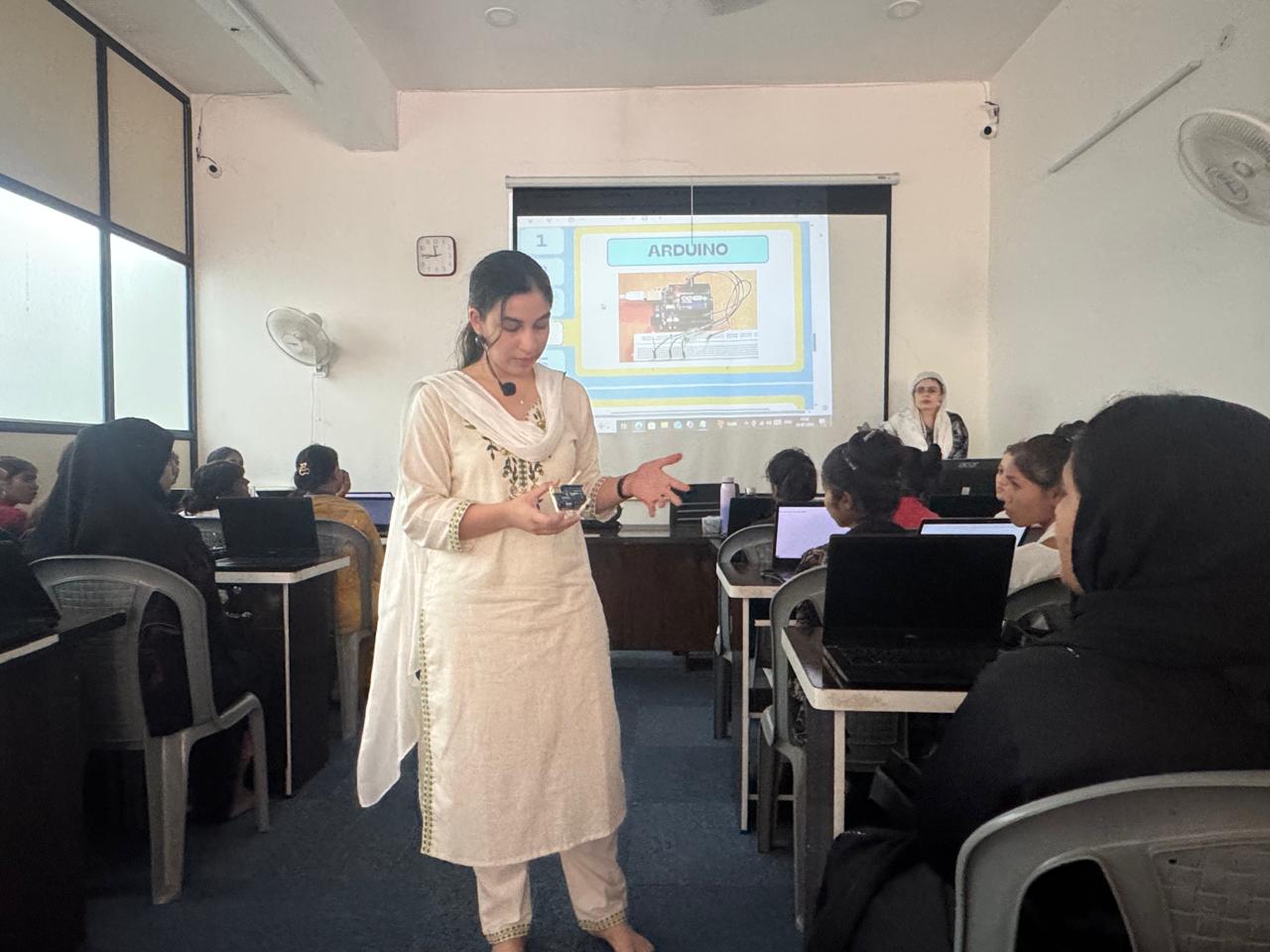 DreamBig volunteer explaining Arduino electronics to students